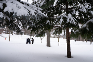 Students walk through a snowy campus. 