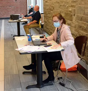 Ruth Sullivan and other SU employees set up desks in Sadler Dining Hall to answer phones and ensure that students who were staying on campus had everything they needed.