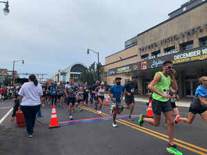 Participants, both running and walking, passed by photos along the route that illustrated the differences in predominantly-Black Syracuse neighborhoods before and after discriminatory infrastructure implementations, like I-81’s construction. 