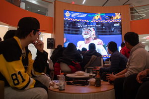 Football fans gather in the Schine Student Center Atrium to watch the Super Bowl LVIII. Viewers indulged in snacks, watched while doing homework and expressed their emotions with groans and cheers.