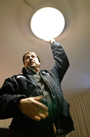 Jimmy Taylor, an employee of FI Xit for 34 years, repairs a ceiling light inside a Marion Hall room.