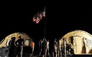 Members of the 79th Expeditionary Rescue Squadron secure the units flag to a pole at Camp Bastion, Afghanistan, on April 10, 2010, when the airmen in the squadron completed their first alert mission.