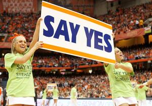 (From left) Sophomores Meghan Clark and Allessandra Hemminger help lead cheers celebrating Syracuse Say Yes to Education during the SU men's basketball game vs. Louisville on Saturday.