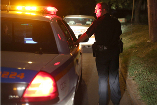 Officer Mike Gabriell, a DPS officer of three years, checks the area during a traffic stop on Ostrom Avenue.