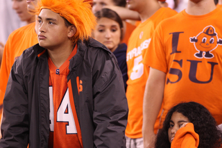 Lizardo Reyes, a freshman communications and rhetorical studies major and Druesila Rivas, a sophomore broadcast journalism major, watch as Syracuse lets up a touchdown.  