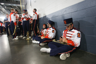 Alexander Todd, a freshman trumpet player in the Syracuse marching band, waits for the game to start. 