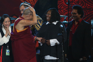 The Dalai Lama and Whoopi Goldberg, emcee of the concert, joke about hair.