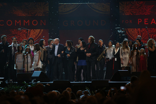 The cast of One World Concert artists performs together on stage.