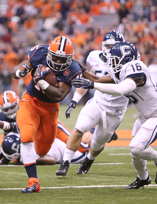 Syracuse running back Jerome Smith powers past UConn defenders before being brought down by UConn defensive back Byron Jones.