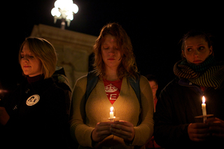 Anne Marie Suchanek, a senior information technology major, gazes at her candle during a moment of silence at the candlelight vigil.