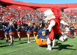 The Rutgers Scarlet Knight mascot runs up as if to kick Otto the Orange.