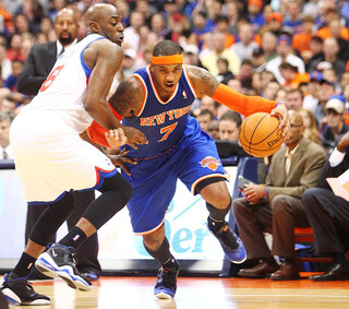 Carmelo Anthony of the New York Knicks drives to the basket against Damien Wilkins of the Philadelphia 76ers.