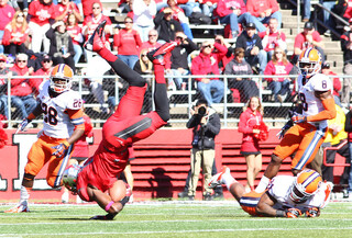 A Rutgers receiver is upended by Syracuse safety Shamarko Thomas (right).