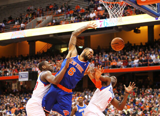Tyson Chandler of the New York Knicks loses control of the ball as he drives to the basket against Damien Wilkins and Lavoy Allen of the Philadelphia 76ers.