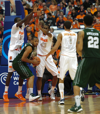 Syracuse center Baye Moussa Keita (left) and James Southerland stick their arms up to double-team a Wagner player in the paint.