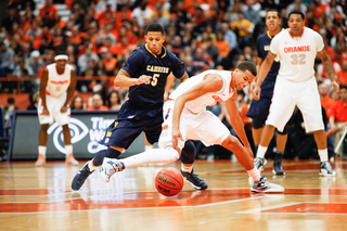 Syracuse guard Michael Carter-Williams fights for a loose ball with Canisius guard Reggie Groves.