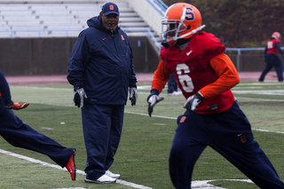Syracuse secondary coach Donnie Henderson looks over at safety Ritchy Desir during practice.