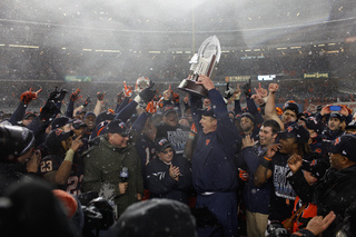 Doug Marrone holds up the Pinstripe Bowl trophy in a ceremony after the game. 