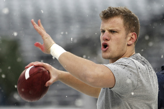 Ryan Nassib passes the ball in blustery conditions on the field before the game.