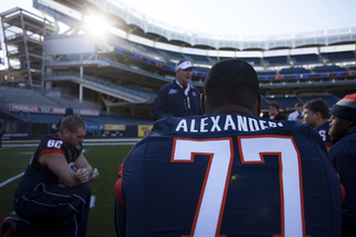 Offensive lineman Lou Alexander (77) listens in as head coach Doug Marrone speaks to his team and area youths at Yankee Stadium.