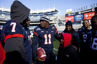 Syracuse linebacker Marquis Spruill stands with a child at Friday's 
