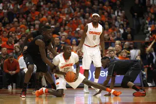 Syracuse center Baye Moussa Keita looks to pass up the court from his knee.