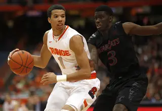 Syracuse point guard Michael Carter-Williams is guarded by Cincinnati forward Shaquille Thomas in the first half.