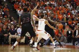 Cincinnati forward Titus Rubles tries to get the ball around Syracuse defenders guards Michael Carter-Williams and Brandon Triche.
