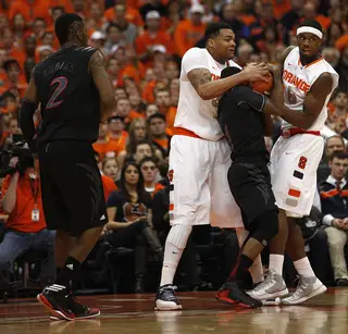 Syracuse forwards DaJuan Coleman and C.J. Fair surround Cincinnati guard Cashmere Wright in an attempt to steal the ball.