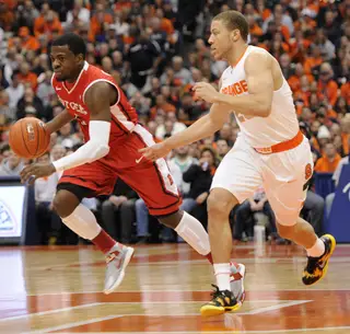 Syracuse guard Brandon Triche defends Scarlet Knights guard Eli Carter.