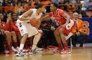 Syracuse guard Michael Carter-Williams looks to pass past Rutgers guard Mike Poole.