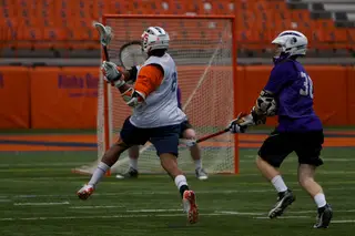 Syracuse midfielder Hakeem Lecky leaps and fires a shot.