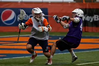 Syracuse attack Kevin Rice sets up the offense from behind the net despite the efforts of the Holy Cross defense.