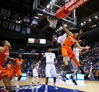 Syracuse point guard Michael Carter Williams gets bumped on a layup attempt as his teammates look on.