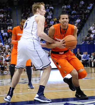 Connecticut swingman Niels Giffey reaches to knock the ball away from Syracuse point guard Michael Carter-Williams.