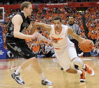 Michael Carter-Williams drives past Nate Lubick.