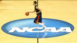 Michael Carter-Williams dribbles the ball over the NCAA logo on the court during practice on the day prior to the start of the second round of the 2013 NCAA men's basketball tournament at HP Pavilion.
