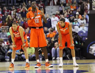 Baye Moussa-Keita #12 of the Syracuse Orange signals to teamates from the court as he stands next to Brandon Triche #20 and Michael Carter-Williams #1 in the game against the Indiana Hoosiers.