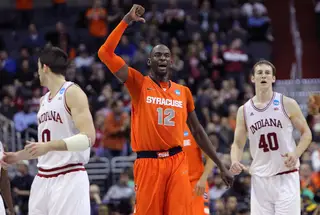 Baye Moussa-Keita #12 of the Syracuse Orange signals to teamates on the court as he smiles during the win over the Indiana Hoosiers.