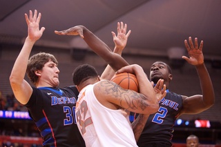 Peter Ryckbosch (left) and Edwind McGhee (right) try to contain Syracuse center DaJuan Coleman.
