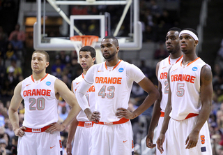 Brandon Triche #20, Michael Carter-Williams #1, James Southerland #43, Rakeem Christmas #25 and C.J. Fair #5 of the Syracuse Orange stand on the court during a break in play.