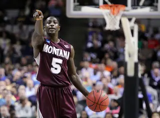 Will Cherry #5 of the Montana Grizzlies points as he takes the ball down the court against the Syracuse Orange 