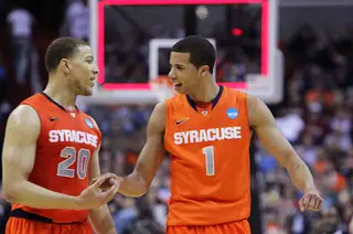 Michael Carter-Williams #1 and Brandon Triche #20 of the Syracuse Orange celebrate as they walk off the court after the first half against the Indiana Hoosiers.