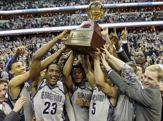 Aaron Bowen (23), D'Vauntes Smith-Rivera and Markel Starks (5) of the Georgetown Hoyas celebrate with teammates as they hold up the Big East regular-season championship trophy.