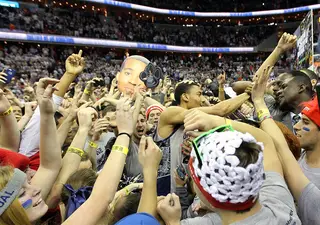 Otto Porter (center) celebrates with Georgetown fans after they storm the court.