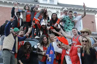 Syracuse University students dance on top of cars, celebrating Syracuse's win outside of Sigma Alpha Epsilon.