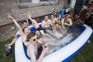 Party Goers celebrate MayFest by relaxing in a pool in front of 423 Euclid Ave.
