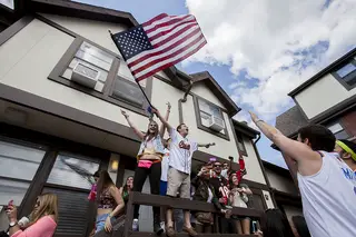 David Okin, a senior, waves an American flag while Dj's play 'America The Beautiful' at Castle's Court, Friday afternoon.