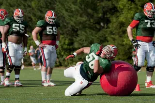 Freshman offensive lineman John Miller blocks around a giant red ball at practice on Tuesday. The interior offensive lineman were working on pulling plays.