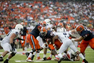 Syracuse running back Jerome Smith runs up the middle, trying to burst by Penn State's Jordan Lucas. 